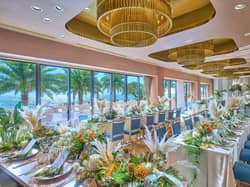 【公式】ヴォヤージュ ドゥ ルミエール 北谷リゾート｜沖縄 北谷 結婚式場 全天候型＆バリアフリーで、すべてのゲストが過ごしやすいご披露宴会場♪壁に鏡を設け多方面から海を楽しめます！サンセットタイムにはより幻想的な空間が披露宴会場を包み込みます。